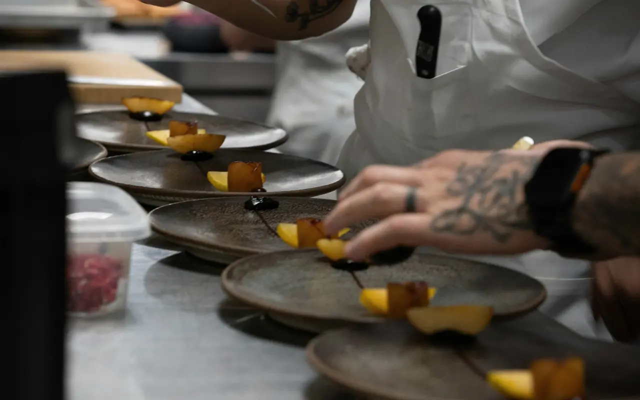 Kok anretter tallerkener i et restaurantkøkken